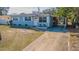 Charming light blue house with a driveway and landscaping at 9696 Groveland St, Seminole, FL 33772