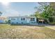 Light blue house with a carport and a small front yard at 9696 Groveland St, Seminole, FL 33772