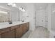 Bathroom featuring double vanity, modern lighting, and spacious glass shower at 17925 Nadine Pl, Nokomis, FL 34275