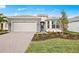 Beautiful single-story home with a well-manicured lawn and a brick-paved driveway leading to a two-car garage at 17925 Nadine Pl, Nokomis, FL 34275