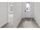 Hallway with wood-look tile floors, white walls, and a decorative glass front door at 17925 Nadine Pl, Nokomis, FL 34275