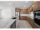 Modern kitchen featuring stainless steel appliances, an island with a marble countertop, and wooden cabinets at 17925 Nadine Pl, Nokomis, FL 34275