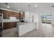 Open-concept kitchen with a large island, stainless steel appliances, and wood cabinetry with built-in oven at 17925 Nadine Pl, Nokomis, FL 34275