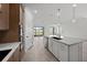 Kitchen with stainless steel appliances, a central island with marble countertop, and a view of the lanai at 17925 Nadine Pl, Nokomis, FL 34275