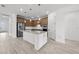 Spacious kitchen with stainless steel appliances, a large island, and wood cabinetry with a built-in oven at 17925 Nadine Pl, Nokomis, FL 34275