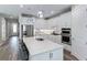 Modern kitchen with white cabinets, quartz countertops, and island with seating at 17925 Nadine Pl, Nokomis, FL 34275