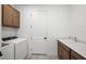 Well-lit laundry room featuring a washer and dryer, sink with cabinets, and a functional layout at 17925 Nadine Pl, Nokomis, FL 34275