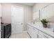 Clean laundry room with white cabinets and new appliances at 17925 Nadine Pl, Nokomis, FL 34275