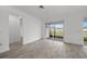 Open living area with wood-look tile flooring, sliding glass doors to the lanai, and recessed lighting at 17925 Nadine Pl, Nokomis, FL 34275