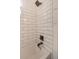 Close up of white subway tile with a rainfall shower head and modern black fixtures at 8903 N Edison Ave, Tampa, FL 33604