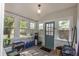 Bright sunroom has many windows and features a green exterior door to the backyard at 8903 N Edison Ave, Tampa, FL 33604