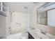 Clean, white bathroom with tiled shower/tub and a vanity with ample lighting and storage at 141 Lakeview Way, Oldsmar, FL 34677