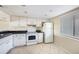 Kitchen features white appliances, tile floors, and white cabinets at 141 Lakeview Way, Oldsmar, FL 34677