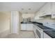 Kitchen features white appliances, and overhead cabinets at 141 Lakeview Way, Oldsmar, FL 34677