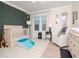 Bedroom with crib, seating, and green accent wall at 3512 W Granada St, Tampa, FL 33629