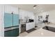 Modern kitchen with white cabinets, teal appliances, and terrazzo floors at 485 41St Ave, St Pete Beach, FL 33706