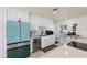 White kitchen with teal appliances and a large island with seating at 485 41St Ave, St Pete Beach, FL 33706