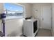 Bright laundry room with washer, dryer, and large window overlooking water at 485 41St Ave, St Pete Beach, FL 33706