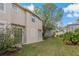 Backyard view of the townhome with green grass and trees at 5230 Blue Roan Way, Wesley Chapel, FL 33544