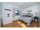 Spacious bedroom with hardwood floors, a striped comforter, and a dresser at 215 35Th Ne Ave, St Petersburg, FL 33704
