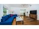 Living room features hardwood floors, a blue sofa, and a modern TV stand at 215 35Th Ne Ave, St Petersburg, FL 33704