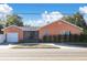 Charming single-story home with a front-facing garage, a landscaped yard, and a classic design under a sunny, blue sky at 463 Park N St, St Petersburg, FL 33710