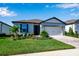 Single-story home with gray exterior, landscaping, and a paved driveway at 9921 Pier Point Ter, Parrish, FL 34219