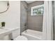 Updated bathroom with grey tile and white fixtures at 205 Kingston S St, St Petersburg, FL 33711