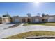 Charming home featuring a well-manicured lawn, extended driveway, and an inviting, gated front patio at 7430 Buchanan Dr, Port Richey, FL 34668
