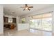 Open-concept living room with tile floors, kitchen, and sliding glass doors leading to a screened lanai at 17929 Timber View St, Tampa, FL 33647