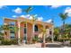 Two-story building with arched entryways, terracotta walls, and palm trees at 2691 Woodette Dr # D, Dunedin, FL 34698