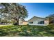 House exterior with a large oak tree and green lawn at 4993 Bostonian Loop # 4993, New Port Richey, FL 34655