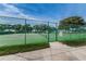 Green tennis court with a fence and gate at 4993 Bostonian Loop # 4993, New Port Richey, FL 34655