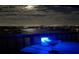 Enjoy cocktails and city lights in the distance from this waterfront balcony view at night under a full moon at 9415 Blind Pass Rd # 905, St Pete Beach, FL 33706