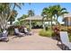 Outdoor patio seating area with gazebo, lounge chairs, and lush tropical landscaping, perfect for relaxation at 9415 Blind Pass Rd # 905, St Pete Beach, FL 33706