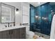 Bathroom with blue tile shower, white vanity, and modern fixtures at 5104 Homer W Ave, Tampa, FL 33629