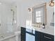 Bathroom with hexagon tile shower, navy vanity, and gold fixtures at 5104 Homer W Ave, Tampa, FL 33629