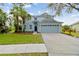 Two-story light blue house with a two-car garage and landscaped lawn at 6029 Gannetdale Dr, Lithia, FL 33547