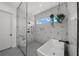 Modern bathroom with walk-in shower, free-standing tub, and geometric tile at 275 44Th Ave, St Pete Beach, FL 33706