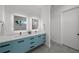 Spa-like bathroom with dual vanities, illuminated mirrors, and blue cabinets at 275 44Th Ave, St Pete Beach, FL 33706