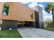 Modern home with wood and dark siding, gray pavers, and attached garage at 275 44Th Ave, St Pete Beach, FL 33706