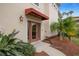 Townhome entrance with awning, landscaping, and modern door at 290 Valencia Cir, St Petersburg, FL 33716