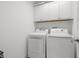 Bright laundry room with washer, dryer and upper cabinets at 290 Valencia Cir, St Petersburg, FL 33716