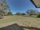 Large backyard with mature trees, grass, and open space at 5364 Boxtree Ct, Dade City, FL 33523