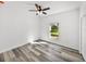 Bright bedroom with ceiling fan, large window, and grey wood-look floors at 5364 Boxtree Ct, Dade City, FL 33523