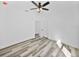 Bedroom with ceiling fan, grey wood-look floors and door to bathroom at 5364 Boxtree Ct, Dade City, FL 33523