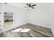 Bright bedroom with ceiling fan, large window, and grey wood-look floors at 5364 Boxtree Ct, Dade City, FL 33523