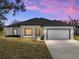 One-story home with attached garage, neutral color palette, and landscaping at 5364 Boxtree Ct, Dade City, FL 33523