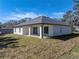 White house exterior with a covered patio, gray roof, and green lawn at 5364 Boxtree Ct, Dade City, FL 33523