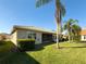 Spacious backyard featuring lush landscaping, a screened lanai, and mature palm trees at 16233 Amethyst Key Dr, Wimauma, FL 33598